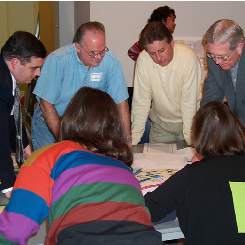 A group of Kenner employees around a table meeting