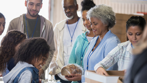 Image of a group of smiling people receiving food 